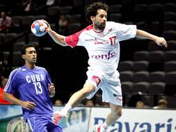 El jugador de la selección española de balonmano Juan García (dcha) trata de rematar ante el cubano Frankis Carol durante el partido que ambos equipos disputaron el domingo./ Efe