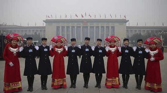 Azafatas posan frente al Gran Palacio del Pueblo en Pekín. 