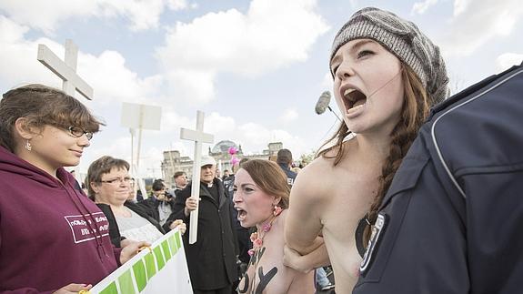 Manifestantes contra el aborto frente a activistas de Femen en Berlín.