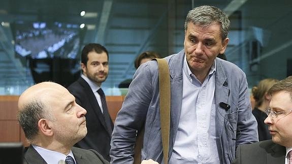 El comisario de Asuntos Económicos, Pierre Moscovici (i), conversa con el ministro giego de Finanzas, Euclides Tsakalotos (c).