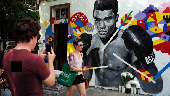 Flores ante un mural de Mohamed Ali en Nueva York.