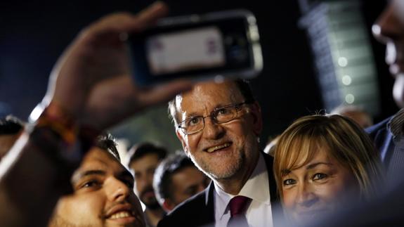 Mariano Rajoy se fotografía con simpatizantes durante su acto de inicio de campaña.