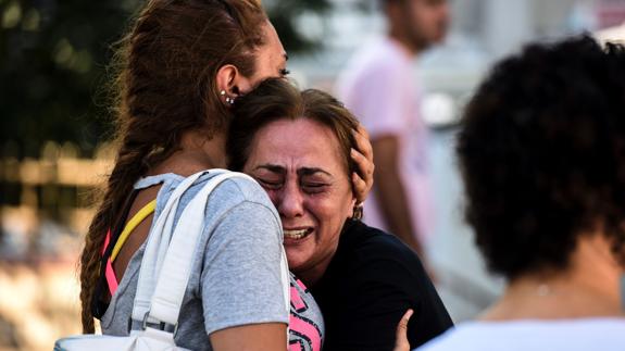 La madre de una de las víctimas es consolada por un familiar.