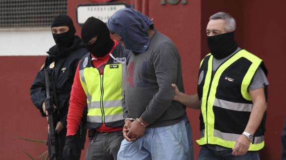 Agentes de la Policía Nacional trasladan al yihadista detenido en Ceuta.