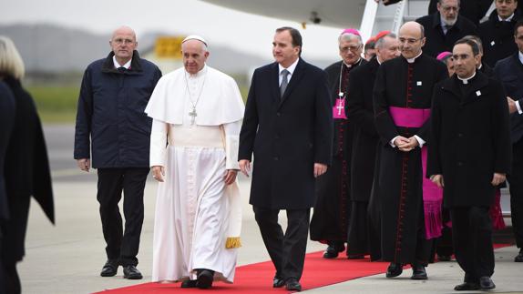 El primer ministro sueco, Stefan Lofven (c-d), da la bienvenida al papa Francisco (c-i), a su llegada al aeropuerto de Sturup, Malmö, Suecia.