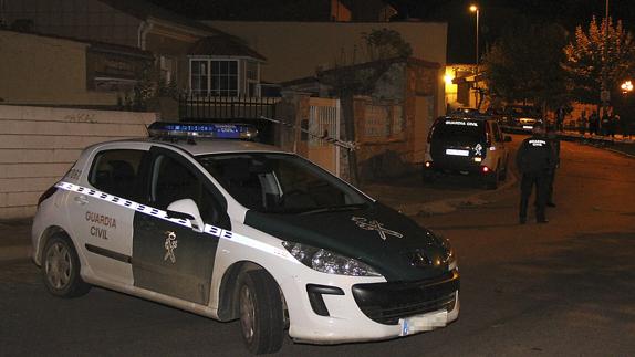 Un coche de la Guardia Civil junto a la vivienda donde han sido hallados los cadáveres. 