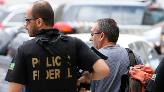 Vizan González (d) es escoltado por un miembro de la Policía Federal de Brasil. 