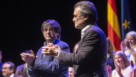 El presidente de la Generalitat, Carles Puigdemont (i), y el líder del PDeCAT, Artur Mas (d).