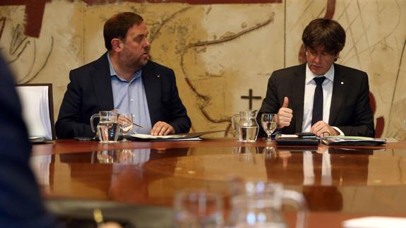 El presidente de la Generalitat, Carles Puigdemont, y su vicepresidente, Oriol Junqueras (i).