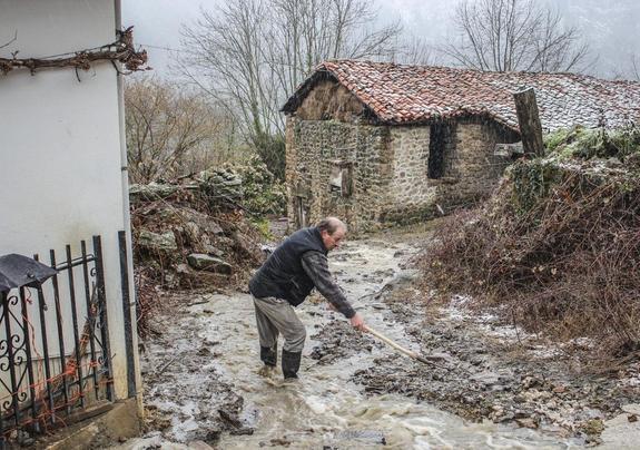  Sebrango. Marcos González trata de canalizar el agua en una calleja de Sebrango.