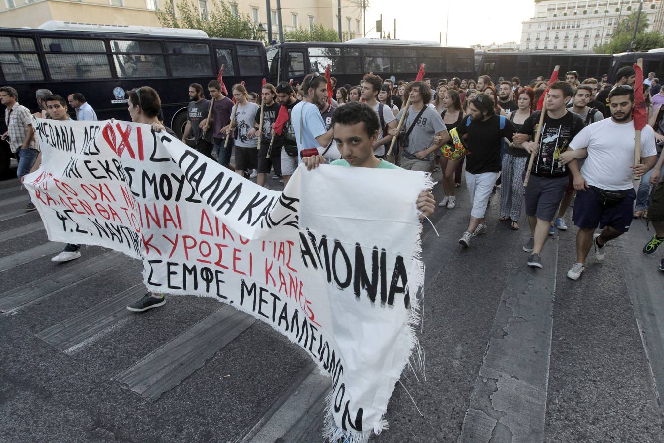 Ciudadanos griegos junto a un grafiti que pone 'no'. 