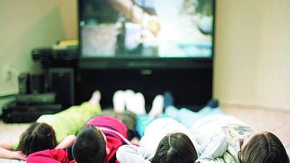 Un grupo de niños viendo la televisión.