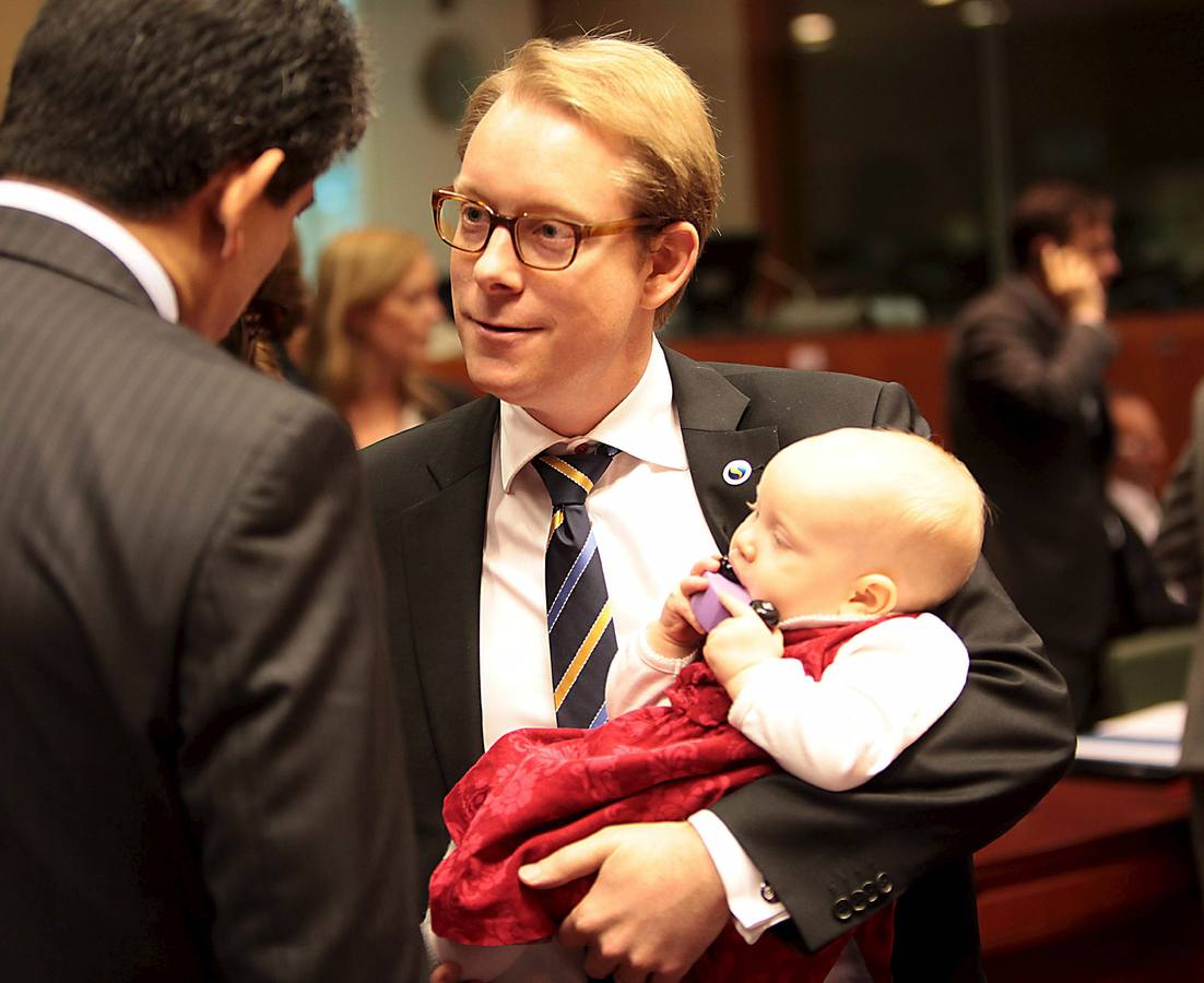 Tobias Billstrom, ministro de Inmigración de Suecia, con su hija en brazos, asiste en Bruselas a una reunión del Consejo Europeo