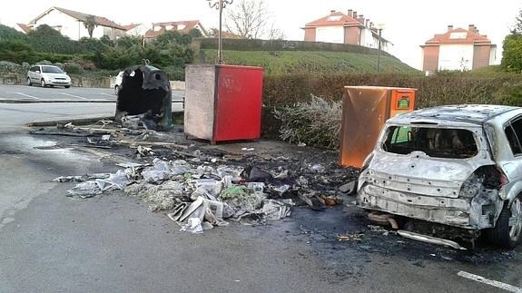 Así han quedado los contenedores y el vehículo incendiados.