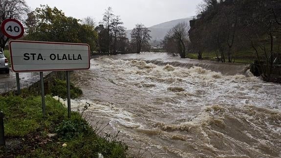 El río Besaya, crecido por las fuertes lluvias, pasa por Santa Olalla.