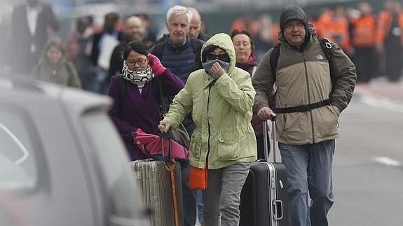 Viajeros dejan la terminal del aeropuerto tras las explosiones