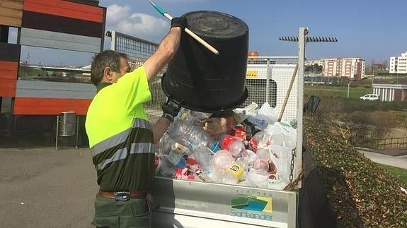 Un operario recoge la basura acumulada en el parque de Las Llamas.