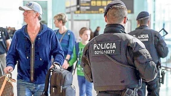 Efectivos de los Mossos d’Esquadra patrullan el aeropuerto de El Prat, en Barcelona, tras los atentados de Bruselas.