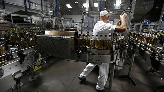 Un operario trabaja en una fábrica de aceite. 