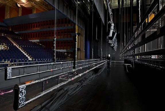 Un operario trabaja en el escenario del Palacio, de 500 metros cuadrados, para preparar el montaje de una función esta misma semana.