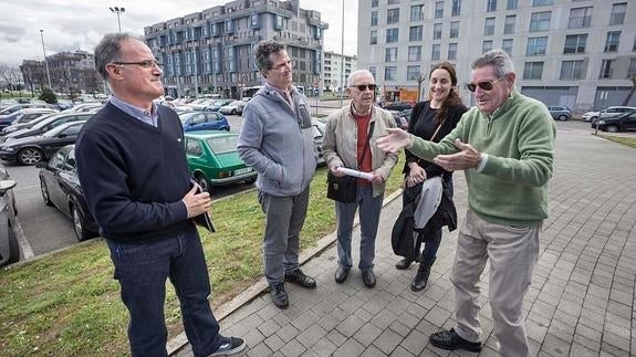 Vecinos veteranos de Nueva Montaña, junto con el párroco Alfonso Valcárcel, cuentan con nostalgia a una nueva vecina cómo era el barrio hace 20 años. 