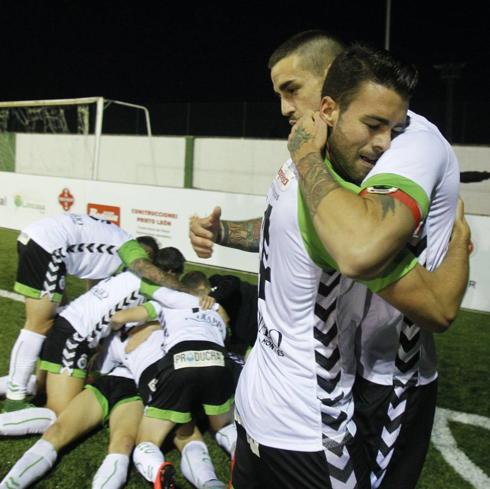 Dani Rodríguez y Borja Granero se abrazan, mientras sus compañeros hacen una ‘montonera’ tras marcar el gol de la victoria en Guijuelo. 