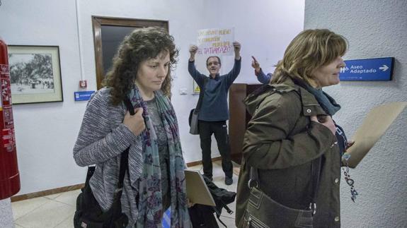 Tatiana Yáñez-Barnuevo, concejala de Ganemos, pasa ante un simpatizante de Santander Sí Puede, Luis Ruiz, con un cartel acusatorio, el pasado mes de abril.