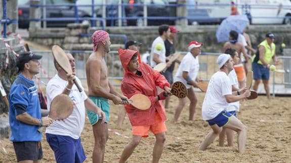 Decenas de participantes en el maratón juegan a las palas en la playa de El Camello, uno de los santuarios de este deporte típico de los arenales cántabros. 