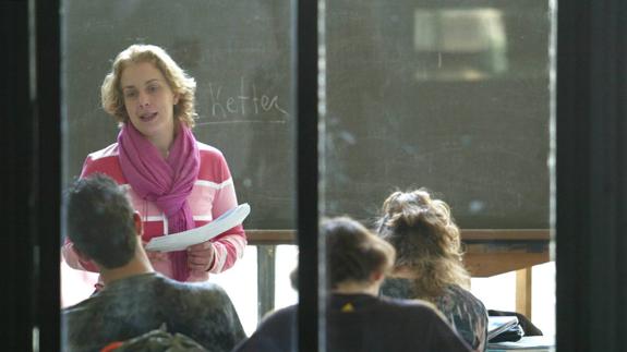 Una profesora da clase en un instituto de enseñanza secundaria.