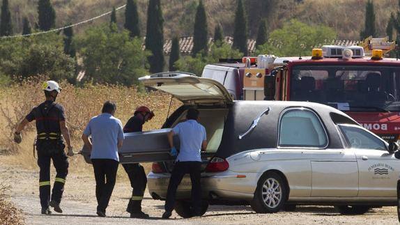 Bomberos y miembros de la funeraria trasladan el cuerpo sin vida del pastor que excavó el pozo de forma artesanal.