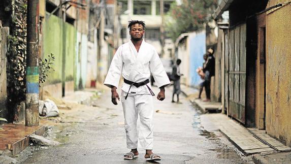 Popole Misenga pasea vestido con su judogi por las calles de la favela Brás de Pina, donde vive.
