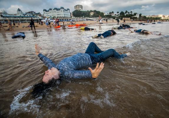 Los participantes en la performance 'Lo que el mar nos trae' compusieron una imagen de gran dramatismo en la Primera de El Sardinero.