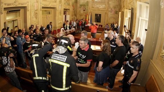 Miembros de la plataforma son desalojados por la Policía Local y los bomberos en una sesión plenaria celebrada en julio.