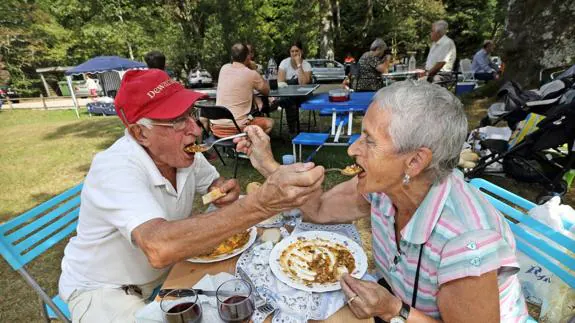 Una pareja disfruta de un plato de cocido montañés en la campa de Ucieda.
