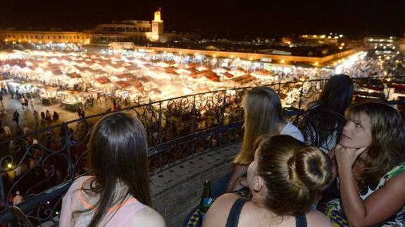 Un grupo de turistas observa desde una terraza la plaza Jemaa el-Fna de Marrakesh. 