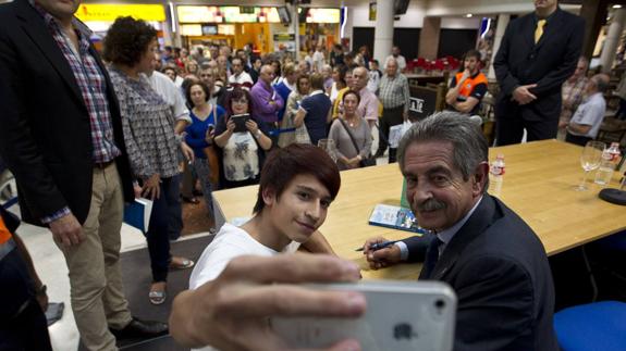 Un joven se hace un ‘selfie’ con Revilla ante la cola para firmar ejemplares. 