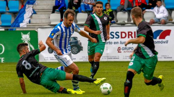 El gimnástico Siro trata de irse con el balón y evitar la entrada del rival del Vimenor.