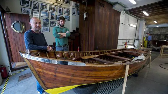 Quico (izquierda) y Álvaro Porres posan junto a uno de los barcos de madera con el que han venido trabajando en su taller de la calle Gamazo, junto a Puertochico.