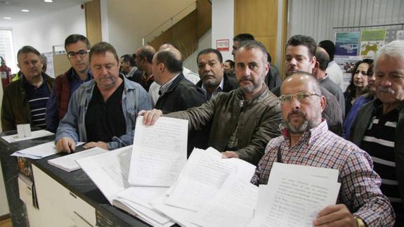 Los comerciantes muestran las 1.200 firmas que registraron ayer en el Ayuntamiento de Laredo.