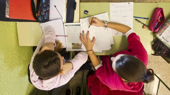 Dos alumnas estudian en el aula de un colegio 