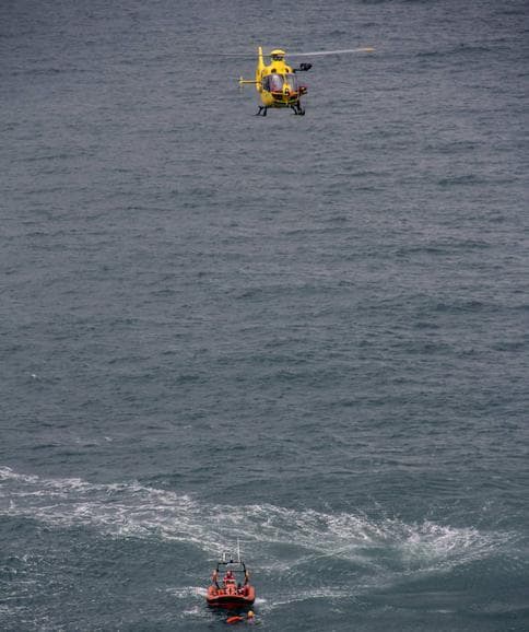 Miembros de Cruz Roja, al lado de la lancha en la que se encuentra el cadáver del pescador.