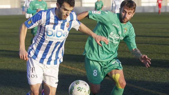 El gimnástico Hugo Vitienes trata de irse con el balón durante el partido de ayer en La Albericia 