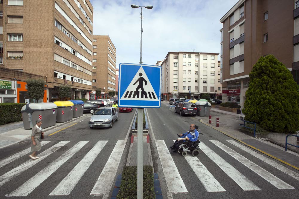 Hombre en silla de ruedas atravesando un paso de peatones en Camargo.