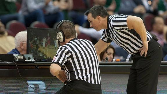 ‘Instant replay’. Dos árbitros revisan una jugada dudosa en un partido de baloncesto de la liga universitaria de Estados Unidos. Ese recurso existe también en la NBA y en Europa.