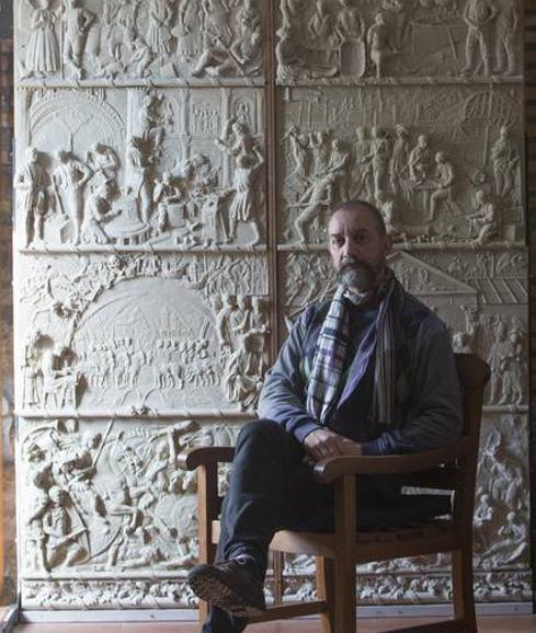 José Antonio Barquín, que estudió en la Escuela de Artes y Oficios de Pamplona de la que luego fue profesor, posa frente a la puerta de tres metros de altura con la historia de Cantabria. 