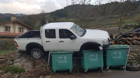 Así se quedó el vehículo, sobre los contenedores de basura.