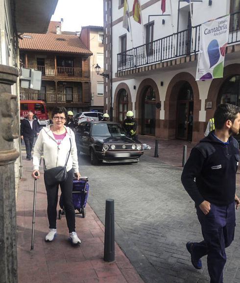 Una mujer pasa junto al coche, ya retirado de la fachada