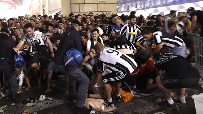 Asistencias y aficionados tratan de ayudar a las víctimas de la avalancha de la plaza San Carlo de Turín el sábado.