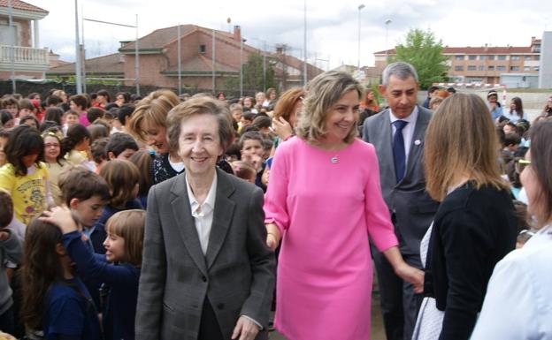 Margarita Salas rodeada de niños de Arroyo en el patio de su colegio. 