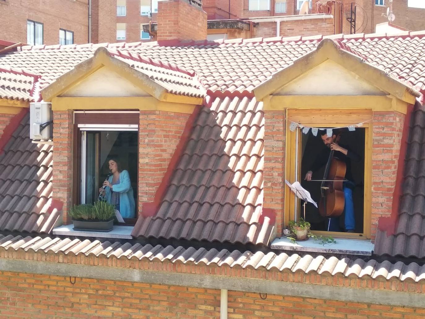 Dos de los músicos de la Sinfónica de Arroyo ensayando en su vivienda durante el confinamiento. 